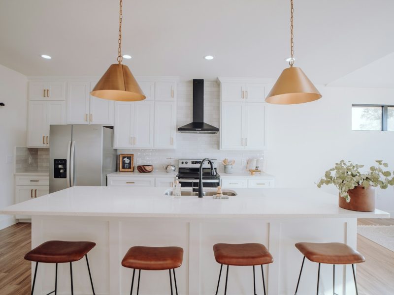 a kitchen with three stools and a center island
